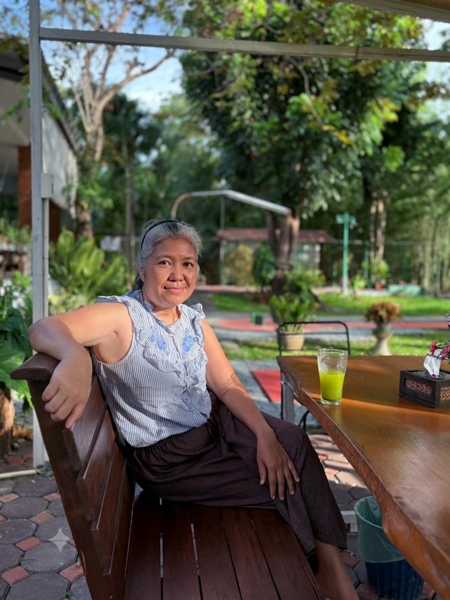 Dr. Sirichan seated in the garden at Green Oasis Resort, San Kamphaeng